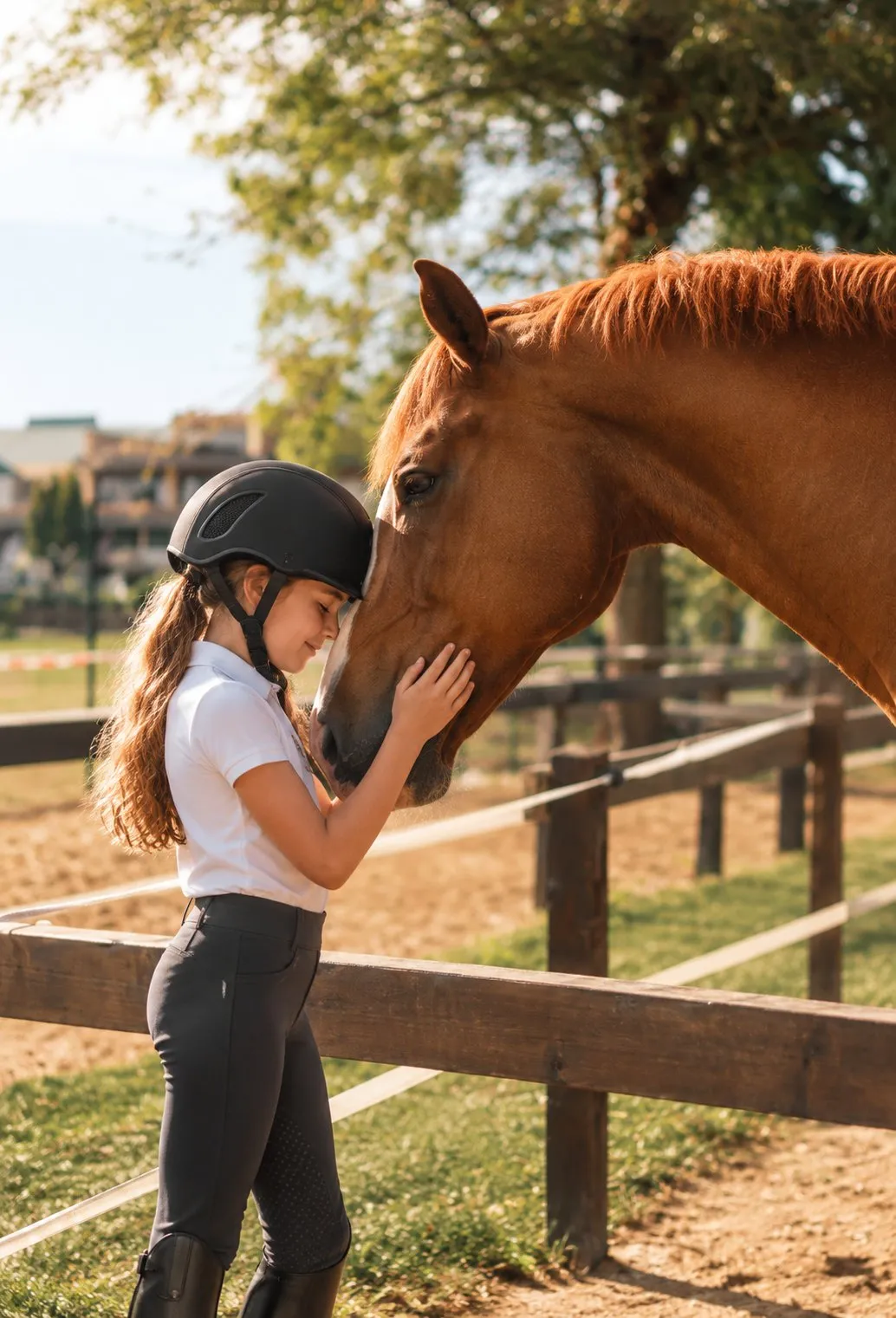 Alumna acariciando a un caballo en la escuela de equitación del CHAS